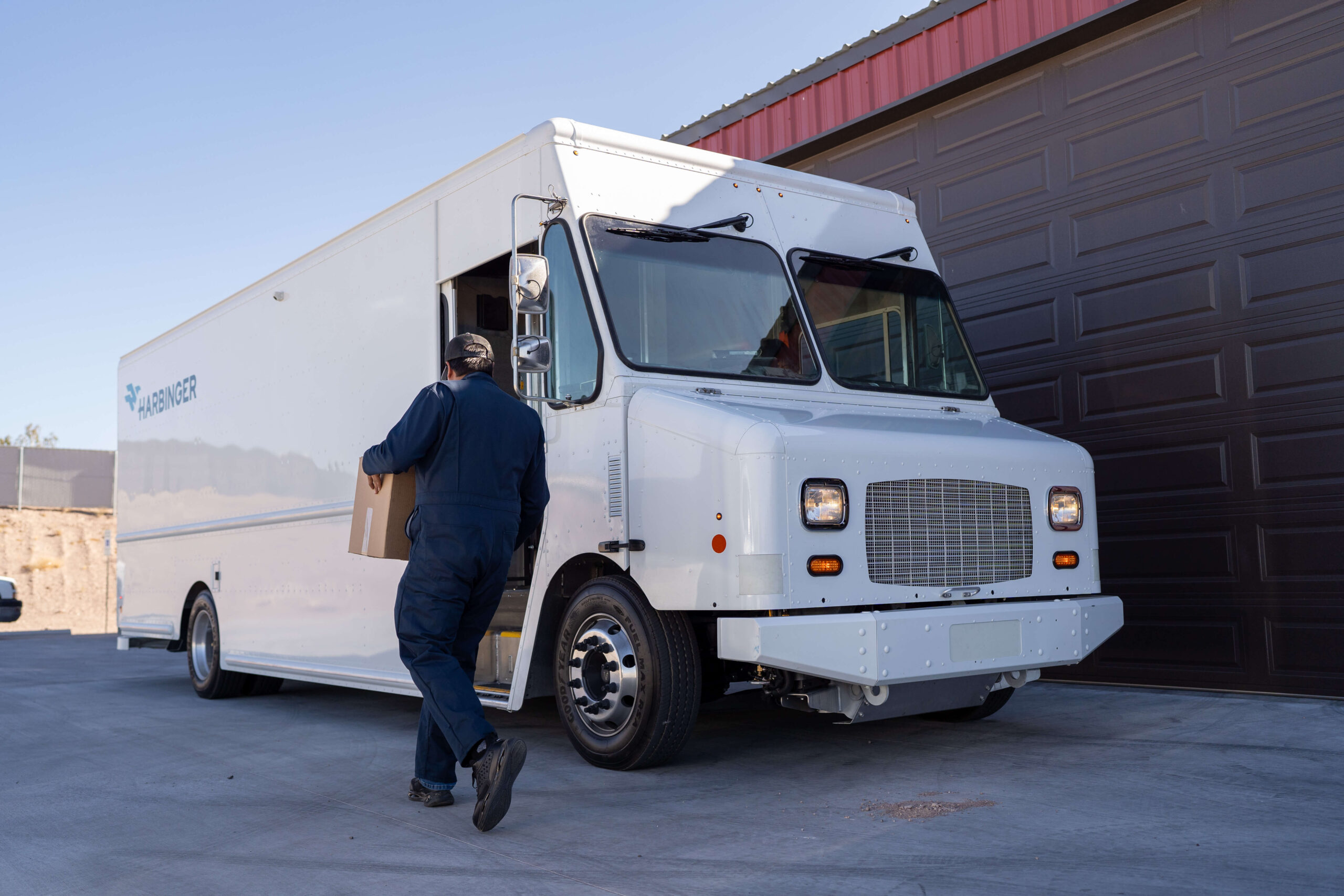 Harbinger EV truck loading at commercial depot.